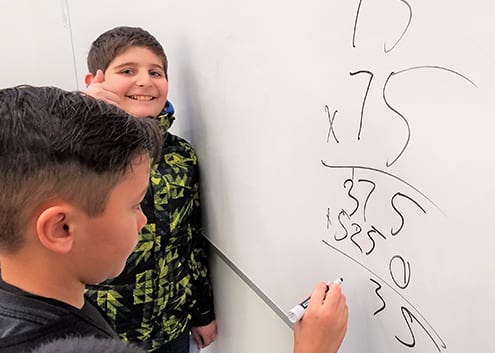Boys & Girls Clubs members do math on whiteboard