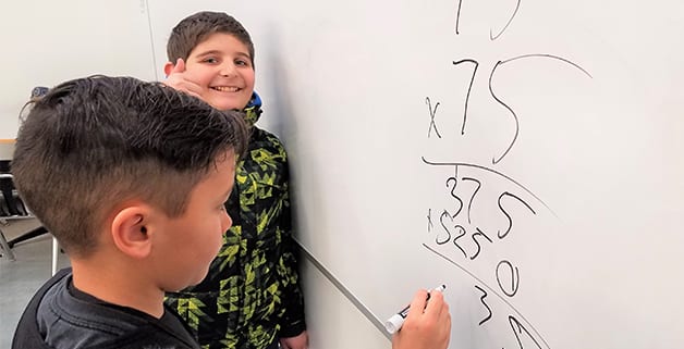 Boys & Girls Clubs members do math on whiteboard
