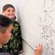 Boys & Girls Clubs members do math on whiteboard