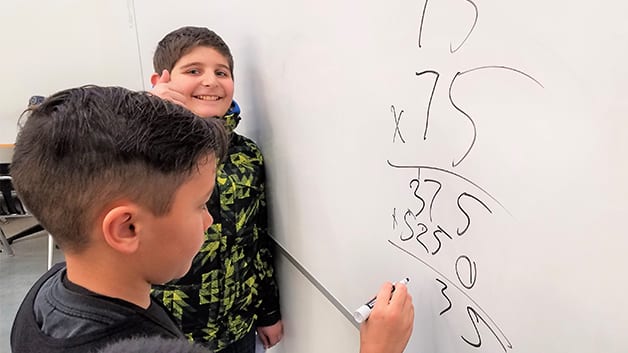 Boys & Girls Clubs members do math on whiteboard