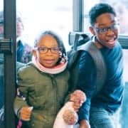 Two children in winter coats coming through doors of Club