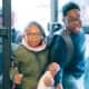 Two children in winter coats coming through doors of Club