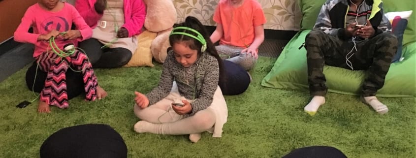 Five children sit, listen to music, and meditate in the Regence Club Peace Room