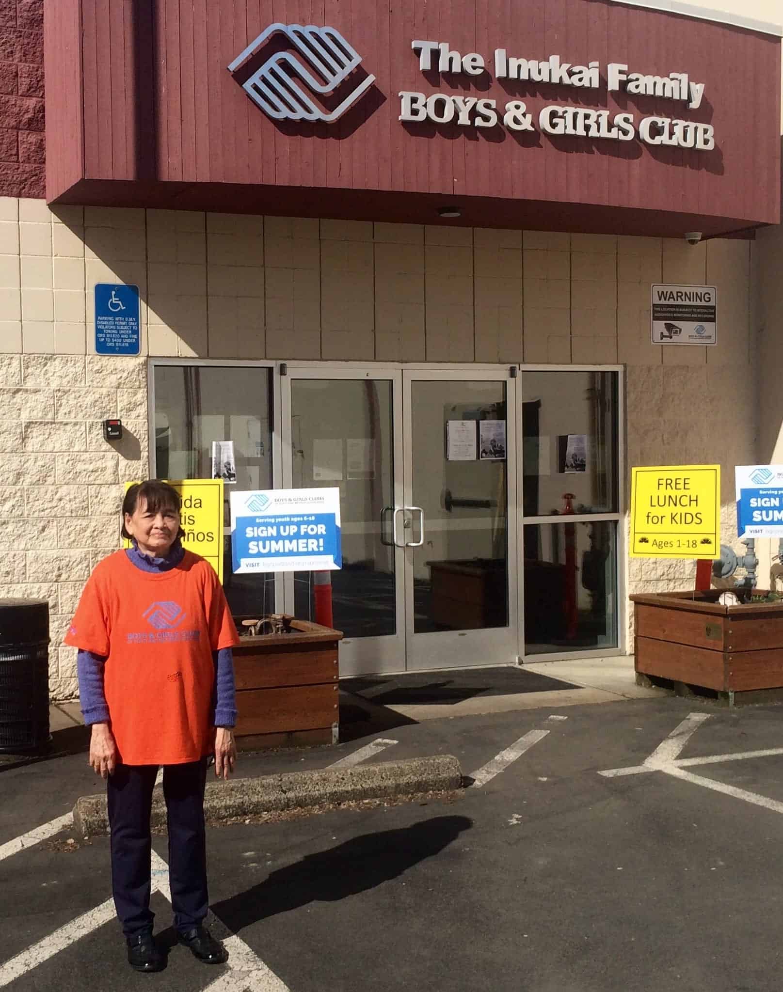 Volunteer Ms. Mena stands outside Inukai Family Club
