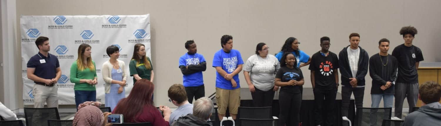 Graduating seniors stand at front of room as they are recognized