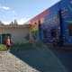 Kids run through inukai play space with entry doors and the rainbow-hued mural in the background.