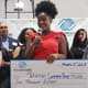Joliesse Carmona Perez on stage giving speech with scholarship check immediately after she was announced as the Portland Metro Youth of the Year by judges on stage behind her..